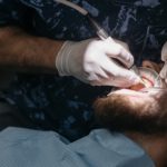 רופא שיניים מטפל בלקוח