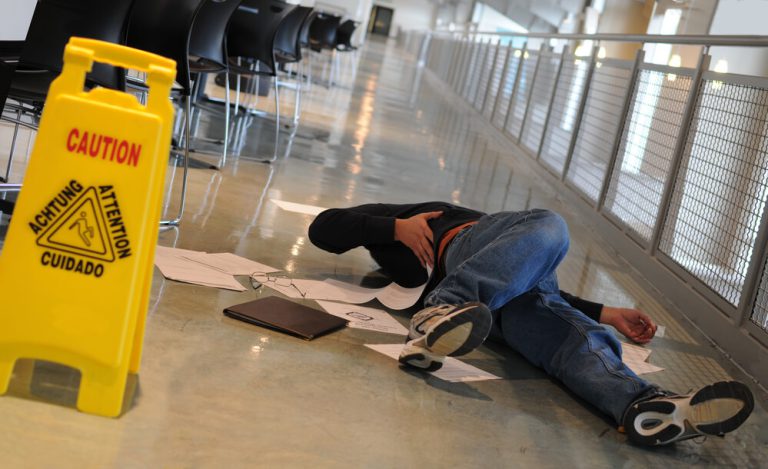 עובד שוכב על הרצפה לאחר נפילה במקום העבודה